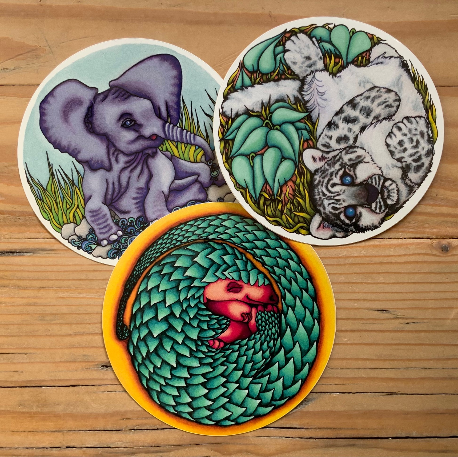 Close up of the three trafficked animal stickers, the elephant calf, snow leopard cub and colourful pangolin baby. Ready to peel and stick.